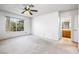 Bedroom with ceiling fan, window overlooking lush landscaping, and ensuite bathroom at 371 Cambray St, Henderson, NV 89074
