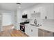 Contemporary kitchen boasts stainless steel appliances, white cabinetry and hardwood floors at 3907 Torsby Pl, Las Vegas, NV 89119