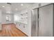 Modern kitchen with stainless steel appliances, white cabinets, and hardwood floors at 3907 Torsby Pl, Las Vegas, NV 89119