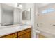 Well-lit bathroom featuring a window, shower-tub combo, and solid wood vanity at 5043 Spencer St # A, Las Vegas, NV 89119