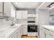 Updated kitchen with white cabinets, modern appliances, white tile countertops, and ample natural light at 5043 Spencer St # A, Las Vegas, NV 89119