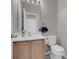 Neutral-toned half bathroom featuring a wood vanity, white sink, and coordinating gray walls at 5228 Giallo Vista Ct, North Las Vegas, NV 89031