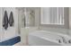 Bright bathroom features a tub with jets, glass shower, and window for natural light at 5228 Giallo Vista Ct, North Las Vegas, NV 89031