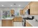 Bright kitchen with stainless steel appliances, wooden cabinets, and a view of the backyard at 5228 Giallo Vista Ct, North Las Vegas, NV 89031
