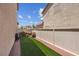 Side yard featuring a narrow strip of artificial grass and firewood storage, ideal for added functionality at 5228 Giallo Vista Ct, North Las Vegas, NV 89031