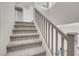 Well-lit, carpeted staircase featuring light wood railings and neutral walls at 5228 Giallo Vista Ct, North Las Vegas, NV 89031