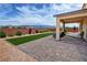 Backyard patio with pavers, turf, and desert landscaping features mountain views at 5528 Eleganza Ave, Pahrump, NV 89061