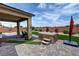 Covered patio with spa, artificial turf, desert landscaping, and brick wall at 5528 Eleganza Ave, Pahrump, NV 89061