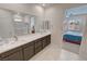 Bright bathroom features dual sinks, a large mirror, and access to the bedroom at 5528 Eleganza Ave, Pahrump, NV 89061