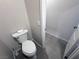 Bathroom featuring a modern toilet and sleek gray tile flooring leading to an open doorway at 5528 Eleganza Ave, Pahrump, NV 89061