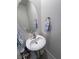 Charming half bathroom featuring a pedestal sink and oval mirror, maximizing space and style at 5528 Eleganza Ave, Pahrump, NV 89061