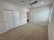 Spacious bedroom with plush carpeting, a ceiling fan, and a closet with sliding doors at 5528 Eleganza Ave, Pahrump, NV 89061