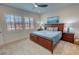 Bright bedroom featuring a ceiling fan, carpet, and a decorative ocean painting above a wood headboard at 5528 Eleganza Ave, Pahrump, NV 89061