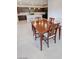 Dining area with a wooden table, four chairs, adjacent to a modern kitchen with stainless appliances at 5528 Eleganza Ave, Pahrump, NV 89061