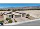 View of a single-Gathering home with a two-car garage, desert landscaping, and a backdrop of mountains at 5528 Eleganza Ave, Pahrump, NV 89061