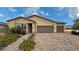 Charming single-story home with desert landscaping and a brick driveway to the attached garage at 5528 Eleganza Ave, Pahrump, NV 89061