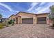 Charming single-story home with desert landscaping and a brick driveway to the attached garage at 5528 Eleganza Ave, Pahrump, NV 89061