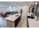 Open-concept kitchen with island seating, dark cabinetry, and seamless flow to dining and living areas at 5528 Eleganza Ave, Pahrump, NV 89061