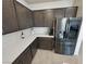Well-equipped kitchen featuring stainless steel refrigerator, stylish backsplash and dark wood cabinets at 5528 Eleganza Ave, Pahrump, NV 89061