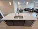Open-concept kitchen with a large island featuring a stainless steel sink, dishwasher, and modern fixtures at 5528 Eleganza Ave, Pahrump, NV 89061