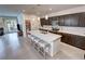 Stylish kitchen featuring a spacious island with seating, dark cabinetry, and modern lighting fixtures at 5528 Eleganza Ave, Pahrump, NV 89061
