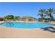Large community pool featuring palm trees, desert landscaping, and bathroom facilities at 5528 Eleganza Ave, Pahrump, NV 89061