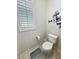 Powder room with neutral walls, a toilet, and a small window with white shutters at 5528 Eleganza Ave, Pahrump, NV 89061