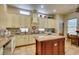 Well-lit kitchen with a center island, tiled floors, and abundant cabinet space for organized living and cooking at 561 Carmel Valley St, Henderson, NV 89012