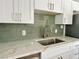 Updated kitchen featuring a stainless steel sink, designer backsplash, and quartz countertops at 604 N Minnesota St, Las Vegas, NV 89107