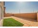 Large backyard with a brick wall and sections of grass, partially covered in dirt at 6148 Vista Teal Ln, Las Vegas, NV 89115