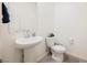 Small bathroom with a pedestal sink, toilet, and modern fixtures at 6148 Vista Teal Ln, Las Vegas, NV 89115