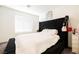 Bedroom with a large, black upholstered headboard and white comforter on the bed at 6148 Vista Teal Ln, Las Vegas, NV 89115