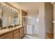 Bathroom features a dual vanity sink, a glass-enclosed shower, and neutral décor at 63 E Agate Ave # 509, Las Vegas, NV 89123