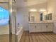 Bathroom featuring a double vanity, separate shower, soaking tub, and modern fixtures at 6638 Babys Tear Pl, Las Vegas, NV 89148