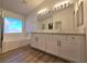 Bright bathroom featuring a double vanity, a soaking tub, and a large window at 6638 Babys Tear Pl, Las Vegas, NV 89148