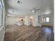 Open concept view of living area, stairs, and kitchen with wood-look floors at 6638 Babys Tear Pl, Las Vegas, NV 89148
