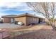 Large landscaped backyard with neutral-tone house, garden bed, blue sky, trees, and utility access at 6781 Southgate St, Pahrump, NV 89061