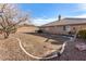 Large landscaped backyard featuring a neutral-tone home, garden bed, and a serene atmosphere at 6781 Southgate St, Pahrump, NV 89061
