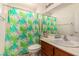Bathroom with floral shower curtain and vanity with sink and ample counter space at 6781 Southgate St, Pahrump, NV 89061