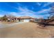 A wide shot of the single-story home with desert landscaping and a long, paved driveway at 6781 Southgate St, Pahrump, NV 89061