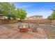 Spacious backyard featuring a brick patio, fire pit, seating, mature trees, and lush green grass at 7028 Weavers Pl, North Las Vegas, NV 89084