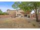Spacious backyard featuring a brick patio, fire pit, seating, mature trees, and lush green grass at 7028 Weavers Pl, North Las Vegas, NV 89084