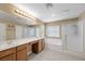 Bright bathroom featuring double sinks, a bathtub, and a separate glass-enclosed shower at 7028 Weavers Pl, North Las Vegas, NV 89084