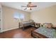 This bedroom features hardwood floors, a ceiling fan and two twin beds that receive natural light from the window at 7028 Weavers Pl, North Las Vegas, NV 89084