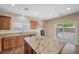 Bright kitchen with an island and bar seating with wood cabinets and stainless steel appliances at 7028 Weavers Pl, North Las Vegas, NV 89084