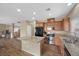 Well-equipped kitchen with granite countertops, wooden cabinets, black appliances, and an island at 7028 Weavers Pl, North Las Vegas, NV 89084