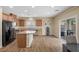 An open-concept kitchen with a large island, wood cabinets, black appliances and wood flooring at 7028 Weavers Pl, North Las Vegas, NV 89084