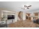 Spacious open-plan living area with wood floors, staircase and a fan enhancing the warm atmosphere at 7028 Weavers Pl, North Las Vegas, NV 89084