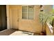 Inviting entrance with a beige door, window, and decorative tree adding charm to the exterior of the home at 7163 S Durango Dr # 113, Las Vegas, NV 89113