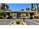 Community entrance with palm trees, gate, and address numbers on the archway at 7163 S Durango Dr # 113, Las Vegas, NV 89113